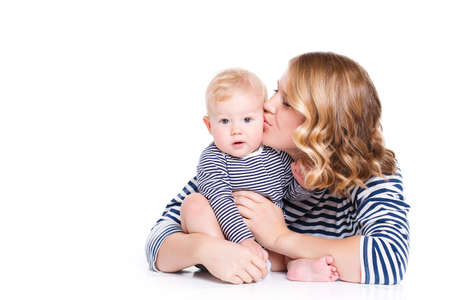 Mother with little baby isolated on white background, young beautiful mom hugging son, pretty brunet woman playing with cute small boy, smiling girl holding adorable sweet child, happy family conceptの写真素材