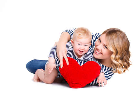 Happy mother and her child with red heart, isolated against white background. childhood, parenting and relationship concept - happy mother with adorable little boy and red heartの写真素材