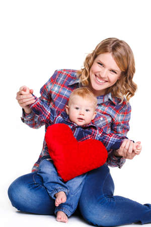 Happy mother and her child with red heart, isolated against white background. childhood, parenting and relationship concept - happy mother with adorable little boy and red heartの写真素材