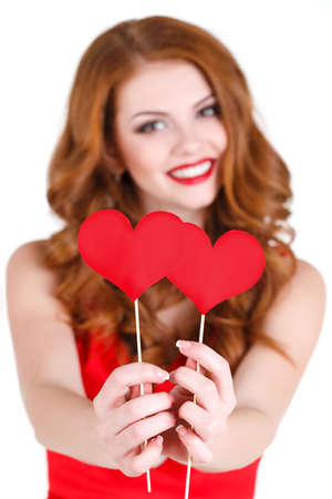 Beautiful young woman with long brown hair, bright makeup, brown eyes, and a red dress with a little...