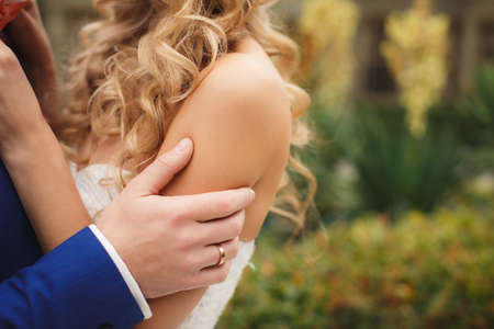 Bride and groom at wedding Day walking Outdoors on spring nature. Bridal couple, Happy Newlywed woman and man embracing in green park. Loving wedding couple outdoor. Bride and groomの写真素材