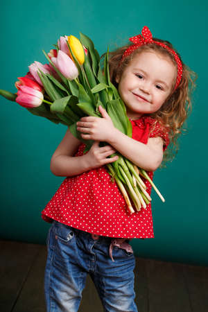 Studio portrait of a pretty little girl child with long curly hair and brown eyes with a large...