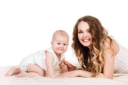 Portrait of a mother and baby isolated on white background on a light beige blanket,brown-eyed baby...