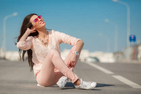 Beautiful brunette with model looks long hairbeautiful smile and white teethpink glassesdressed in a...