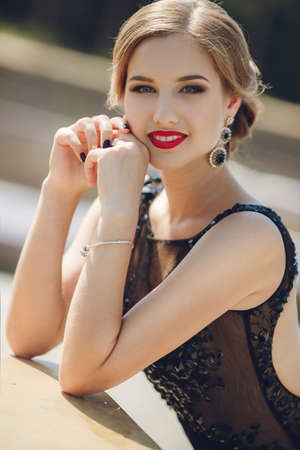 Fashion outdoor photo of beautiful sensual woman in luxurious sequin dress posing in summer park. fashion photo of beautiful tender woman with dark hair in elegant dress posing in summer gardenの写真素材