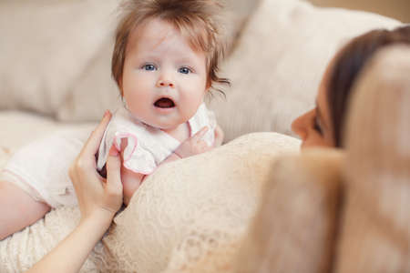 Portrait of a young happy family, mother is a beautiful woman, a brunette with long hair in a braid...