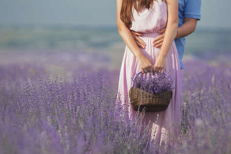 romantic young couple, a man and a woman during summer vacation spending time in the lavender fields in Provence, southern France, recognized each other in love, flowers, hands, arms, the intoxicating scent of flowers.の写真素材