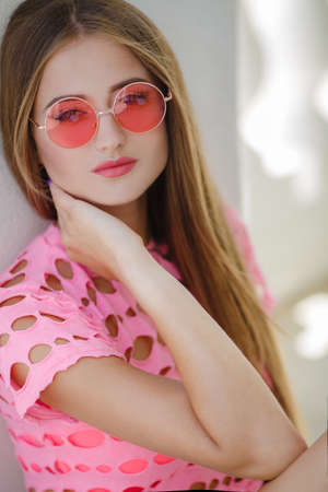 Portrait of the young beautiful smiling woman outdoors enjoying summer sunの写真素材