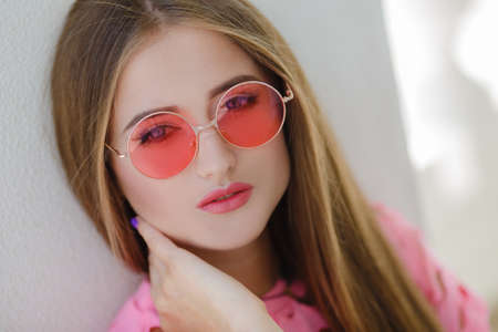 Portrait of the young beautiful smiling woman outdoors enjoying summer sunの写真素材