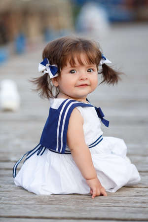 playful baby girl crawling. sea style. outdoors. happy child. Sailor style. Yachting. sea bridge. Smiling girl outdoorsの写真素材