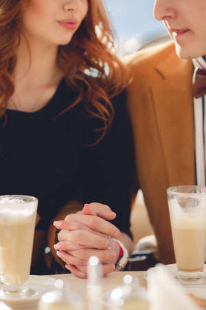 couple in cafe drinking coffee and laughing. Couple drinking coffee at cafe restaurant man and woman with cup of espresso hot cappuccino on dating. Concept of male and female hands love and coffee.の写真素材