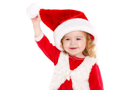 Beautiful girl dressed as Santa Claus.Cute little girl with blond curly hair and brown eyes, a nice smile, dressed as Santa Claus with a big red cap on his head, Studio portrait on white background.の写真素材