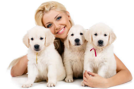 Beautiful blonde with a small white puppy of Labrador, Studio portrait of beautiful woman with long...