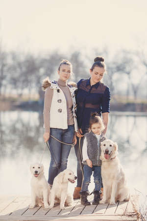 Three sisters, beautiful girls, brunettes, hair pulled back, spend time together with their beloved...