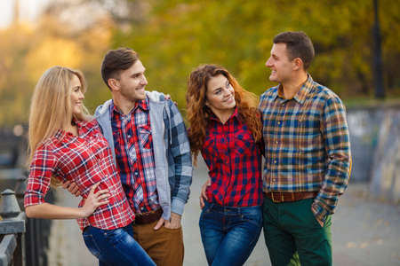 Group Of Friends Having Fun Together Outdoors. Happy group of friends talking and having fun outdoors. friends outdoor. women and men together having fun in city park.の写真素材