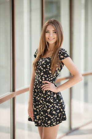 Young woman brunette with long straight hair and gray eyes, long black eyelashes, a cute smile,...