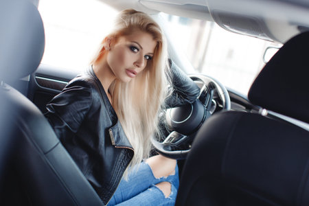 Young woman driving a car in the city.Successful, attractive, beautiful, young woman - blonde,...