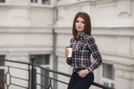 People emotions natural beauty and lifestyle concept - Young beautiful stylish woman walking in a plaid shirt smiling. Closeup portrait of a happy young woman smiling summer street outdoorsの写真素材