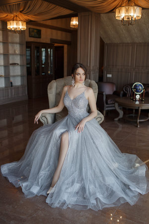 Beautiful woman in elegant evening dress. Brunette Girl with Long Healthy and Shiny Hair. Beautiful young woman dressing outdoors. A portrait of a beautiful woman. Fashion, evening dresses for events.の写真素材