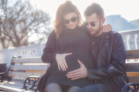 It is a beautiful sunny city. Happy couple is expecting a baby. The concept of love and family...