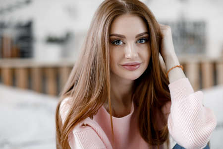 Pretty female sitting on the bedの写真素材