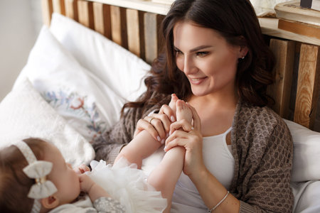 Baby feet in mother hands.Tiny Newborn Baby's feet on female hands closeup. Mom and Child.Mom doing...