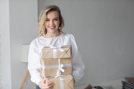 Young beautiful woman with long curly hairs isolated on white. Sexy and gorgeous blonde woman.Portrait of an attractive female posing at studio.Closeup face of a beautiful girl with makeup gray eyesの写真素材