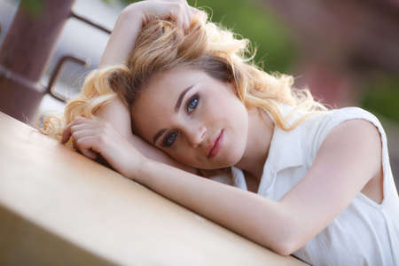 Young beautiful blonde caucasian woman walking summer streets. Beautiful girl, urban portrait.Young attractive woman with perfect smile, summer outdoor portrait. Charming cheerful girl smiling and looの写真素材