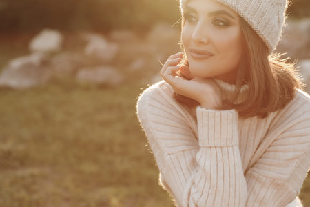 Natural beauty attractive young girl, portrait in a warm sweater in the park in early spring at...
