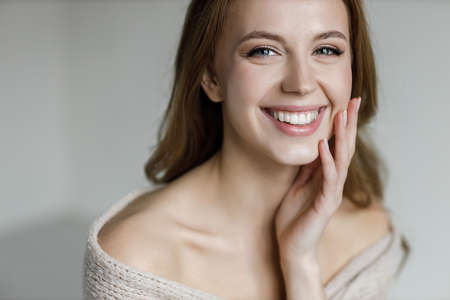 Beautiful face of an attractive model with gray eyes. Smiling Woman with long brown hair and natural makeup Closeup portrait of a caucasian female Happy young woman Young woman with long straight hairの写真素材