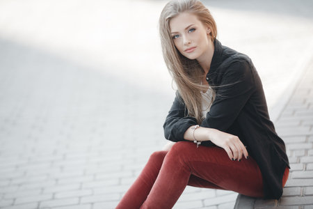 Stylish beautiful smiling attractive woman with long straight hair, blonde with blue eyes, wearing a...