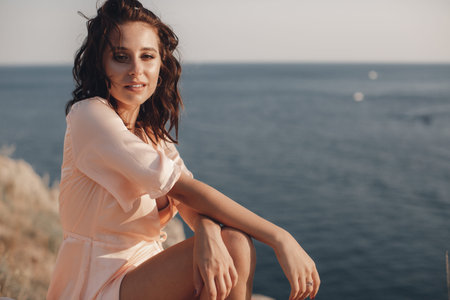 Portrait of a beautiful girl close-up on sea background. Summer portrait on the beach. young pretty girl. Young smiling woman outdoors portrait. Young woman on a rocky coast.の写真素材