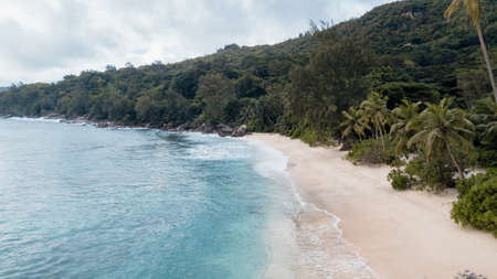 Aerial view of beautiful tropical beach with turquoise water, white sand and coconut palm trees. Seascape from drone.の写真素材