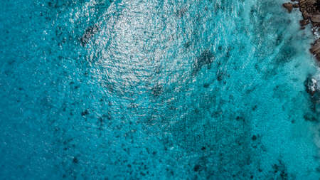 Aerial view of turquoise sea water with waves and foam.の写真素材