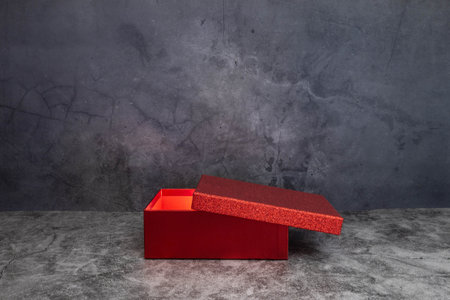red semi-open box with light inside on dark background