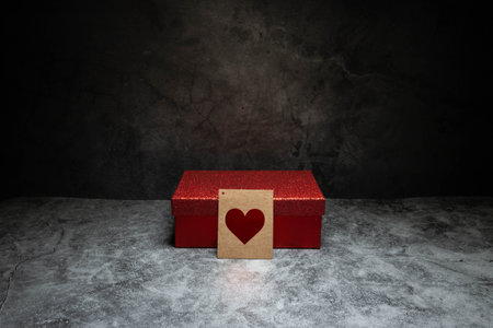 red box on dark background with a card containing a red heart in the centerの写真素材