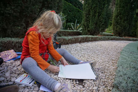 little girl painting in the beautiful gardenの写真素材