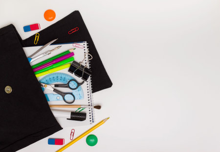 Concept of education, school children and students. Black backpack with office supplies, white...