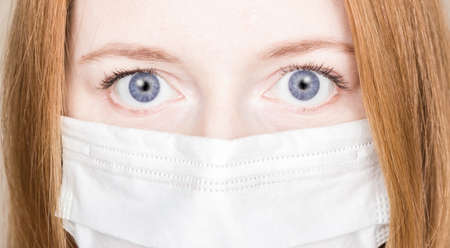 Close- up of a woman's face in a medical or surgical mask. Concept of personal protection in a pandemic, COVID-19の写真素材