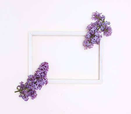 White wooden frame on a white background and lilac flowers. Free space for text, mockup.の写真素材