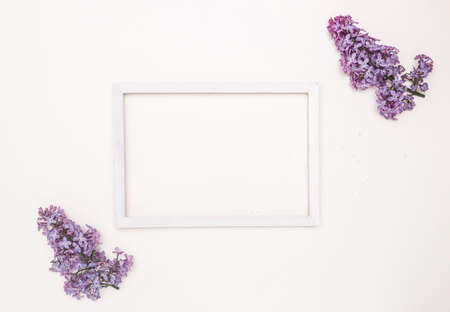 White wooden frame on a white background and lilac flowers. Free space for text, mockup.の写真素材