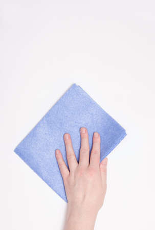 Part of the hand with a blue cloth for dusting and removing dirt. Cleaning, white background, free space for text.の写真素材