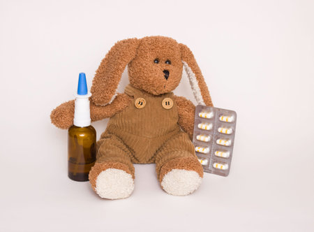 Soft children's toy dog with medicines and tablets next to it. Concept of children's health and...