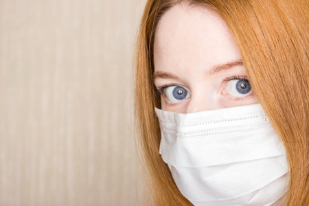 Close up horizontal image woman wear facial medical or surgical mask. Photo banner for website header design. COVID-19 protection at pandemic infectious disease outbreak.の写真素材