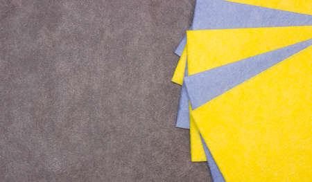 Yellow and blue square rags for cleaning, dusting on a gray background. Free space for text.の写真素材