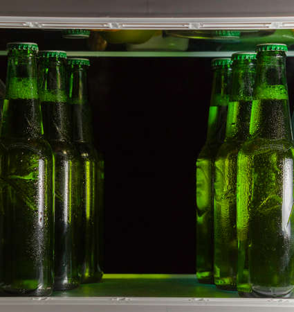 Green beer bottles on the shelf in the refrigerator. The fog on the glass.の写真素材