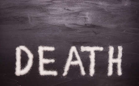 The concept of the harm of sugar. The words "DEATH" are made of sugar on a black background.の写真素材