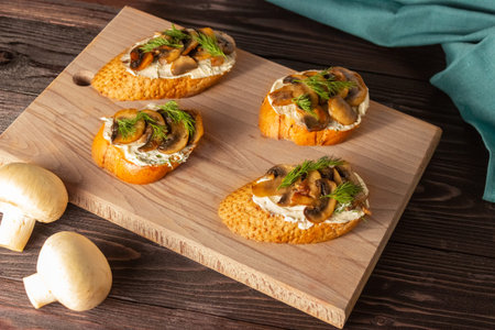 Baguette toast with soft cream cheese and mushrooms on a wooden Board. Snacks, quick breakfasts.