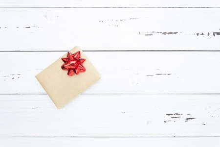 Gift on a white wooden background with a red bow. Top view, free space for text, flatly.の写真素材