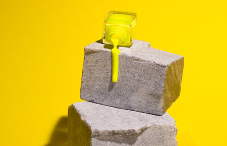 Yellow nail Polish flows on gray concrete stone. Trending Colorsの写真素材